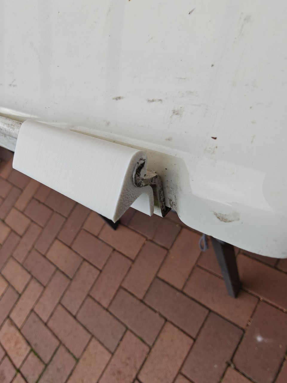 Probestück einer neu gefertigten Einhängeleiste wird am Wohnwagen auf Genauigkeit geprüft